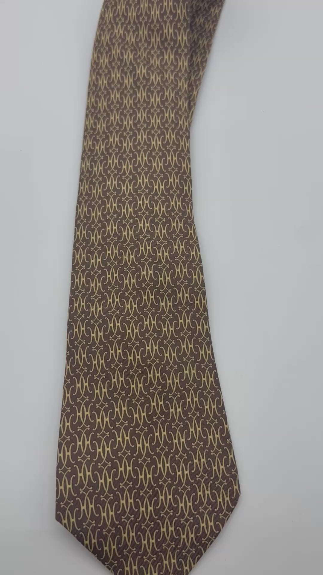 Corbata Hermés café clarito con H amarillas